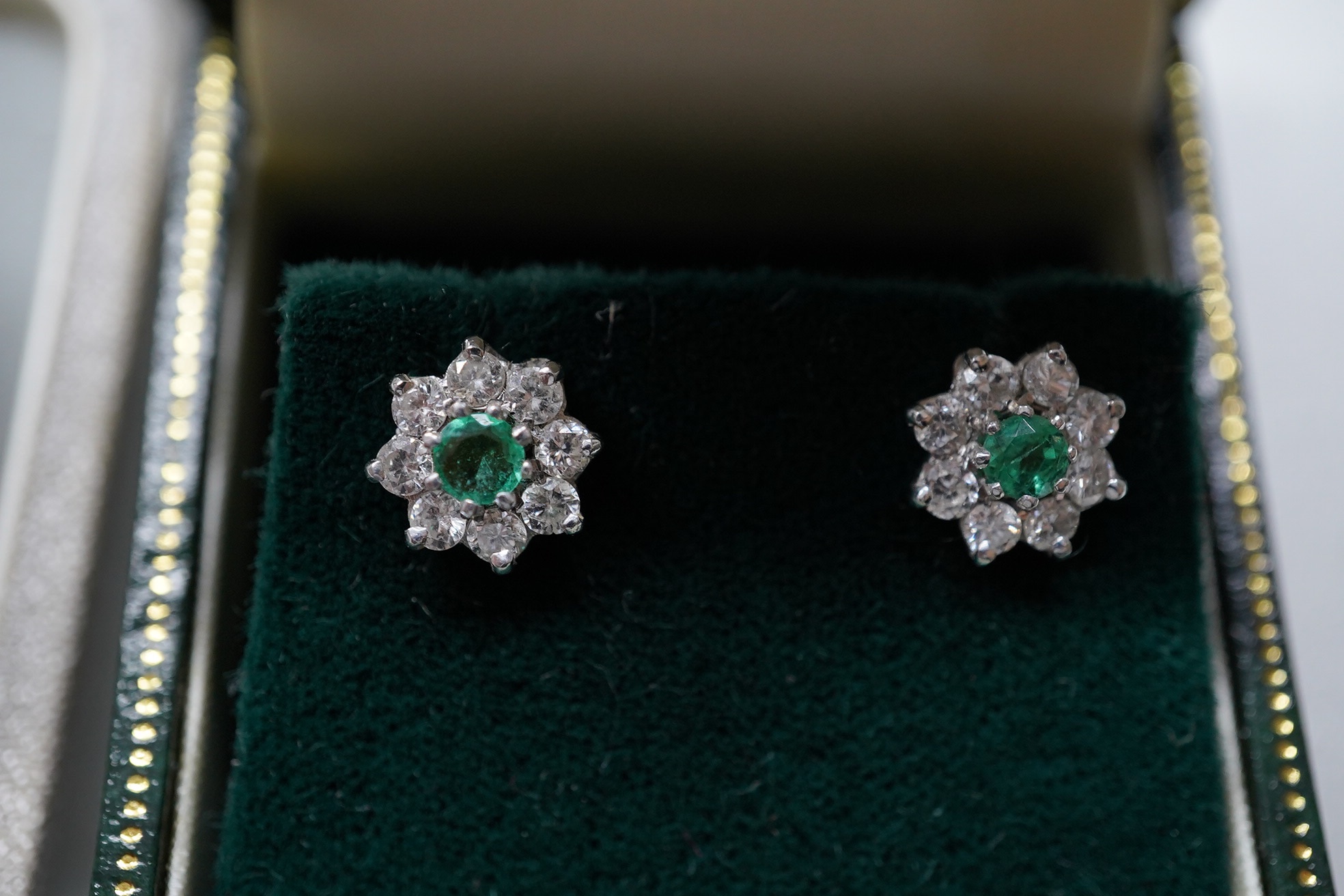 A modern pair of 9ct, emerald and diamond set flower head cluster ear studs, 8mm and a similar pair of sapphire and diamond cluster ear studs. Condition - fair to good